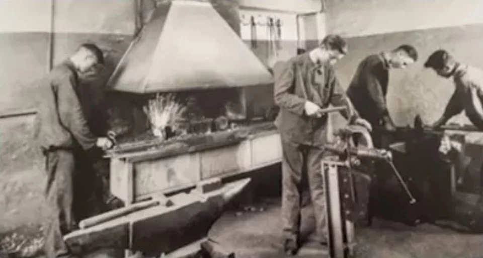 Historical photograph of industrial workers in a factory hall